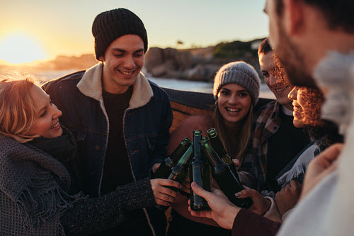 Multi-ethnic people toasting beers on the beach