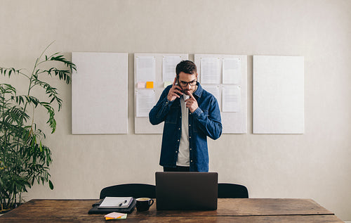 Businessman taking a phone call in a creative office