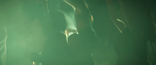 Friends dancing together in the smoke at a festival