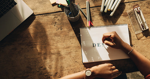 Creative freelancer drawing on a note pad