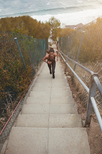 Fit young woman running up the steps