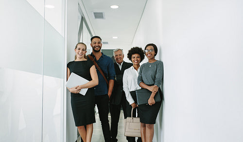 Multiracial corporate professionals in office hallway