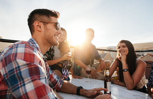 Young guy at rooftop party with best friends