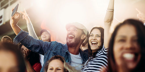 Couple taking selfie while watching a match at stadium