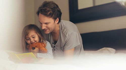 Father and daughter reading a story book