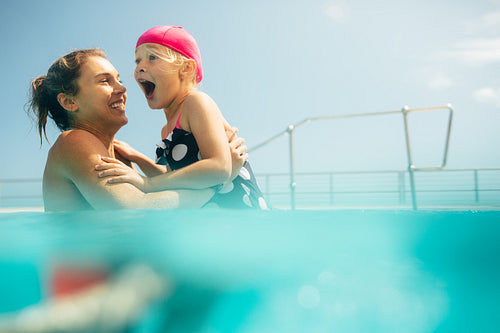 Mother and daughter having fun in the pool