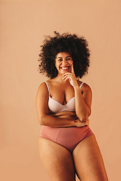Cheerful woman with an Afro hairstyle wearing underwear in a studio