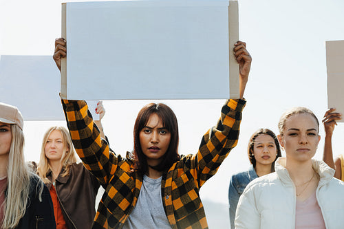 Diverse group of young women holding blank signs during a peaceful protest