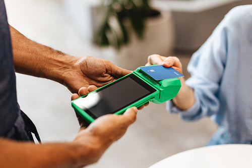 Woman tapping her credit card to make a payment using NFC