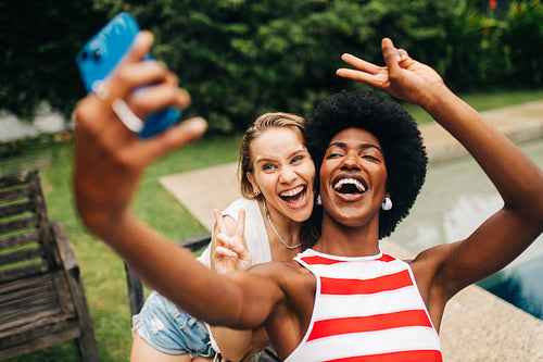 Friends take a joyful selfie by the pool