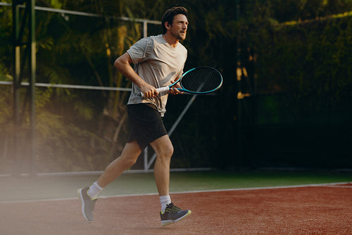 Athletic male playing tennis