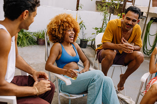 Group of friends enjoying drinks and laughter on a sunny patio