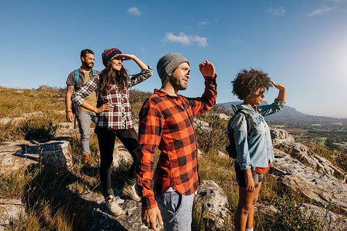 Group of hiking friends enjoying the view from mountain peak
