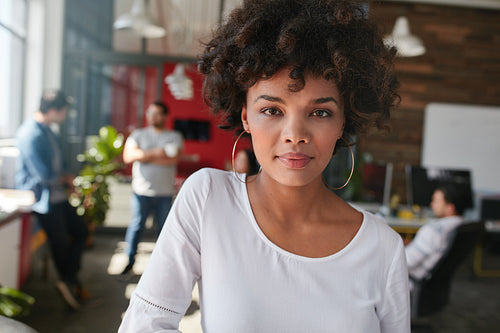 Confident young female designer standing in her office