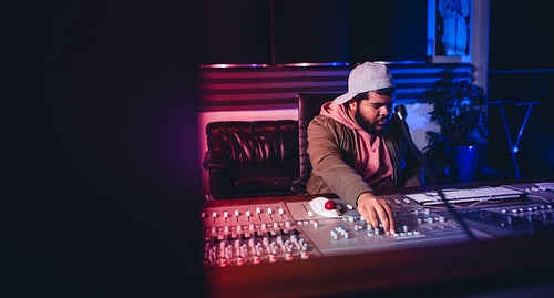 Engineer working on sound mixing desk in recording studio