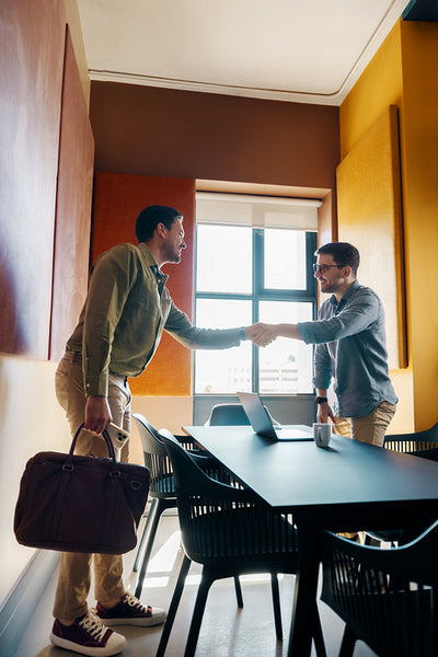 Two professionals shaking hands during a meeting in a modern office space
