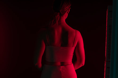 Rearview of a woman receiving red light therapy on her back