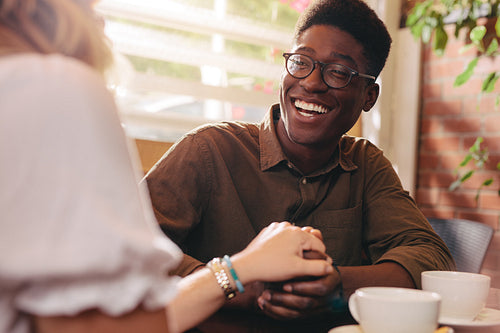 Cheerful couple in love sitting at a coffee shop