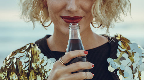 Woman having soft drinks at beach