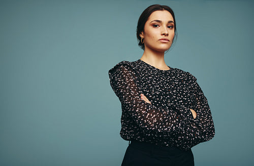 Strong independent young woman standing alone in a studio