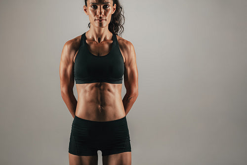 Muscular woman with arms behind back
