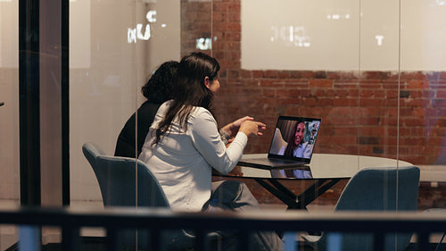 Two professional woman engaging in an online meeting, discussing business through a laptop