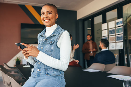 Millennial businesswoman smiling at the camera in a boardroom
