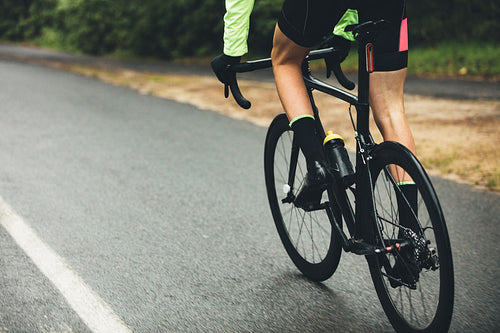 Athlete cycling on country road