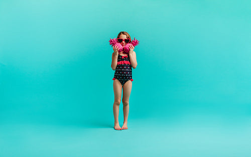 Girl in swimwear with two pink pineapples