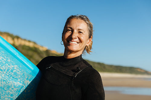 Mature woman enjoying active lifestyle with surfing at the scenic beach