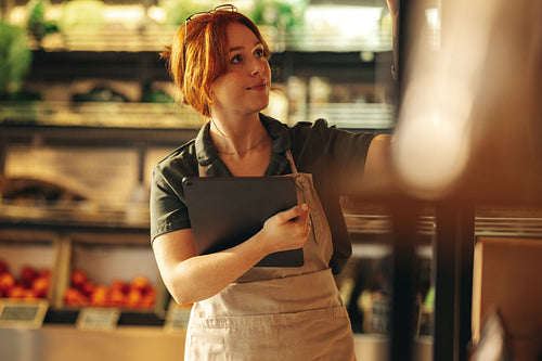 Grocery store owner taking inventory in her shop