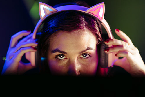 Game on: Female gamer puts on her headset as she prepares for a video game