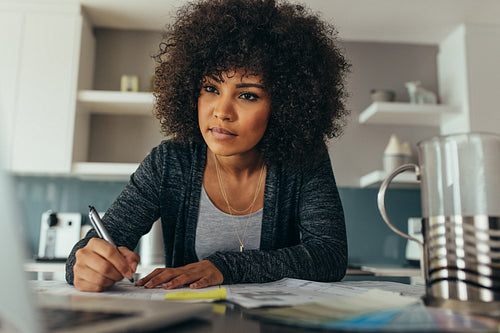 Young female architect working on blueprint