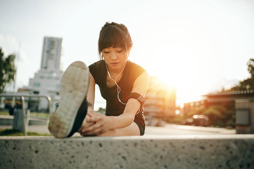 Female runner stretching legs before her workout