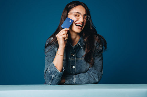 The joy of financial freedom: Woman laughter with credit card in studio