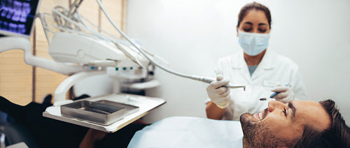 Male patient getting dental checkup in clinic