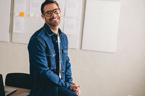 Happy young businessman having a conference call using earbuds