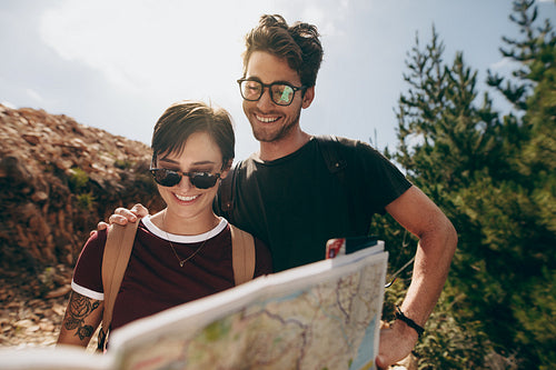 Couple holding a map to find the route to their destination