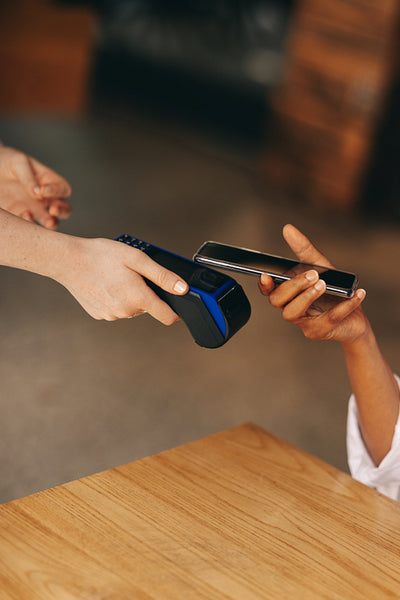Cafe customer paying her bill using NFC technology