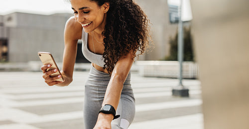 Fitness woman using mobile phone while exercising