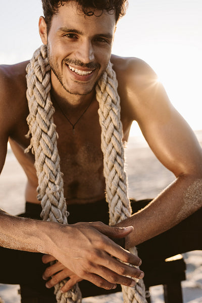 Man relaxing at the beach after workout