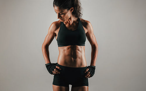 Strong fit young woman showing off her abs