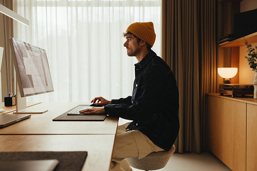 Man analyzes data dashboards on computer at desk