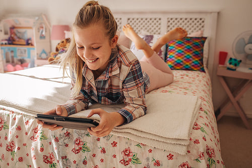 Girl in her room using digital tablet