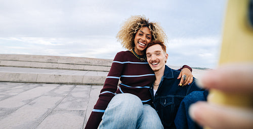 Smiling couple taking a joyful selfie outdoors