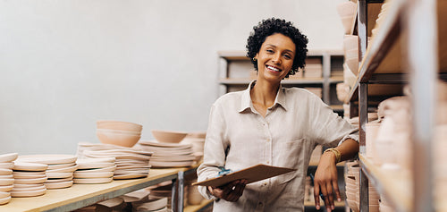 Successful ceramist smiling at the camera in her store