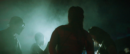 Friends enjoying music festival at night with neon lights and smoke