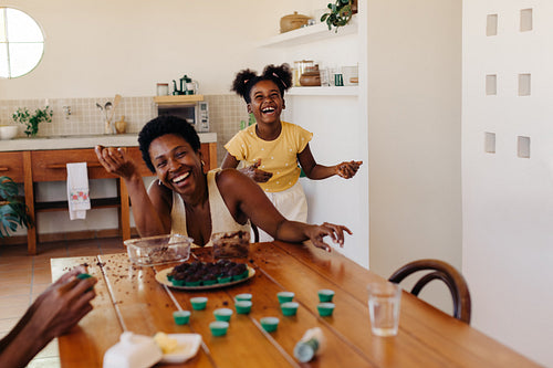 Making Brazilian brigadeiro at home: Happy mother and daughter rolling chocolate truffles for a birthday
