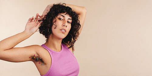 Confident young woman showing her decorated arm pits