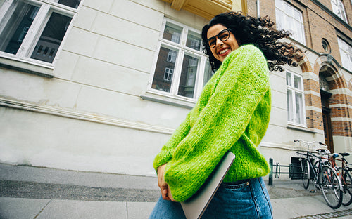Business on the move, the woman walks in the city with a laptop